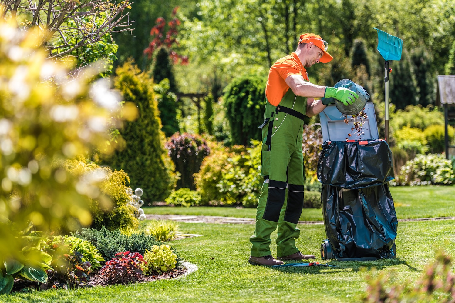 Caucasian gardener working in the green garden and cleaning it from leaves and grass Home Maintenance Services Westminster